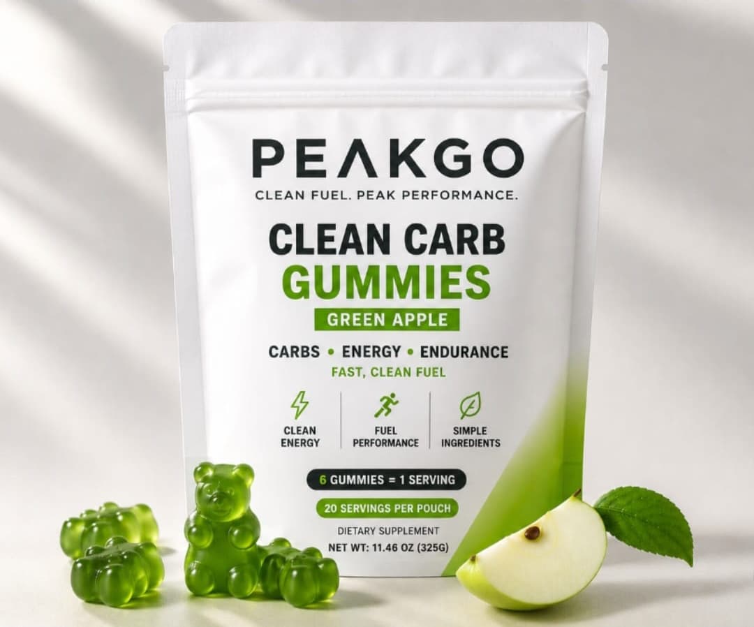 A pouch of PEAKGO Clean Carb Gummies in Green Apple, with green gummy bears and a slice of apple in front of it.